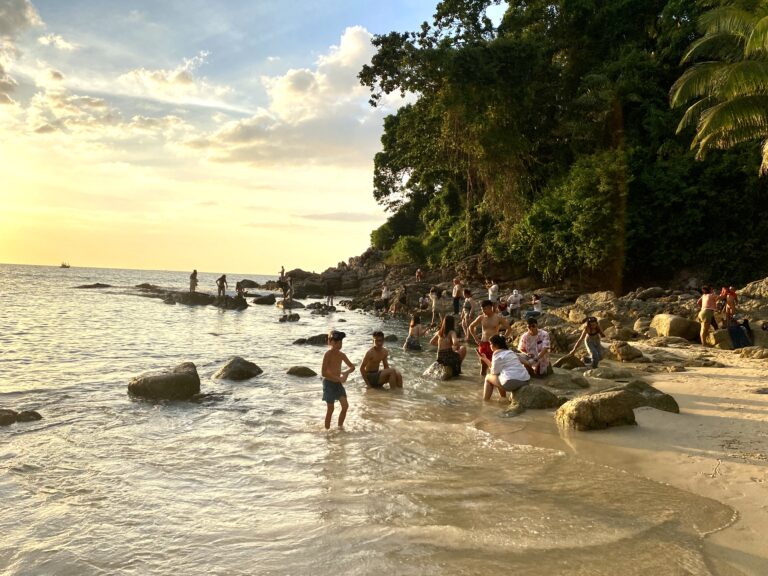 foto di un gruppo di thailandesi che fanno il bagno al tramonto
